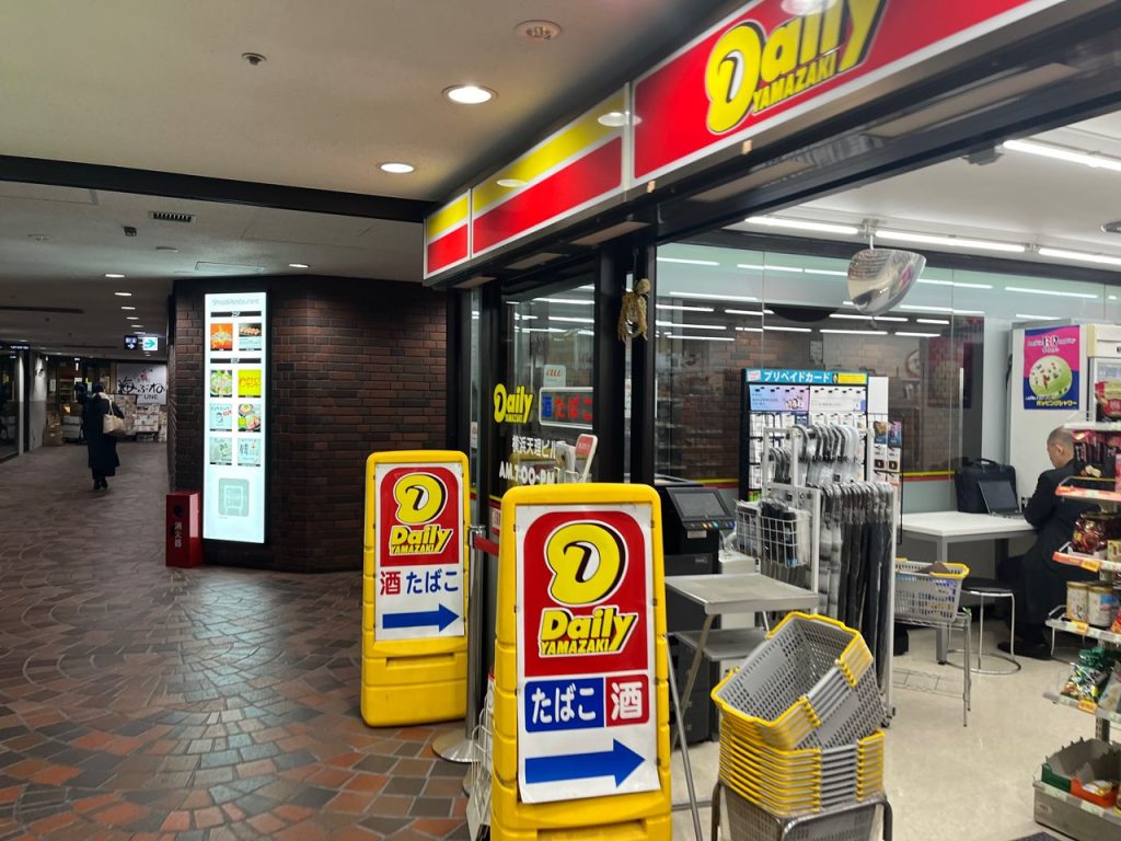 横浜天理ビル地下1階のデイリーヤマザキ横。この先の通路を奥へ進みます